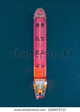 aerial view of a bulk carrier at evening showcases a stunning display of lights reflecting off the water as the massive vessel cuts through the waves. Royalty-Free Stock Photo #2285879113