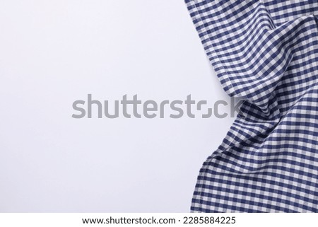 Blue checkered tablecloth on white background, top view