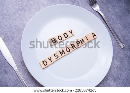 flat lay photo showing the word body dysmorphia on a plate. BDD is a mental disorder Royalty-Free Stock Photo #2285894263