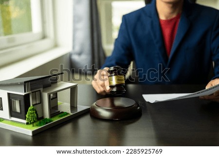 Judge and lawyer at auction with auction house model, house concept, real estate auction concept