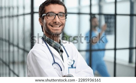 Cheerful mature doctor posing and smiling at camera, healthcare and medicine.