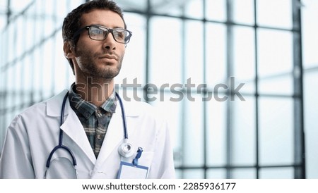 a young doctor stands alone in the studio and poses for the camera Royalty-Free Stock Photo #2285936177