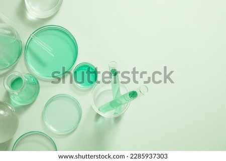 Laboratory glassware filled with green liquid arranged on white background. Blank space for organic beauty product advertising, copy space for text Royalty-Free Stock Photo #2285937303