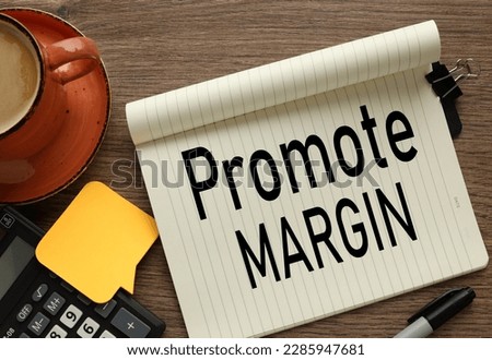 PROMOTE MARGIN. Finance and business concept. On a wooden background lies a calculator and yellow stickers with the inscription - PROMOTE MARGIN.