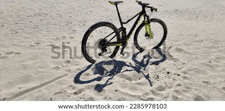 In this picture, we see an individual using a mountain bike to stay fit and active on an island. The scenery around the rider is breathtaking, with a mix of sandy beaches and towering mountains i