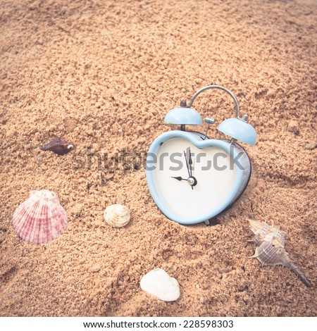 blue old retro clock on sand beach and sea shell vintage color tone,abstract background to memory of last time. 
