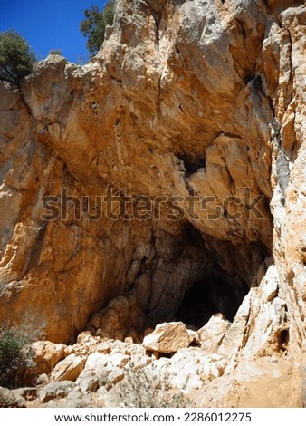 reddish stone cave with blue sky in the background