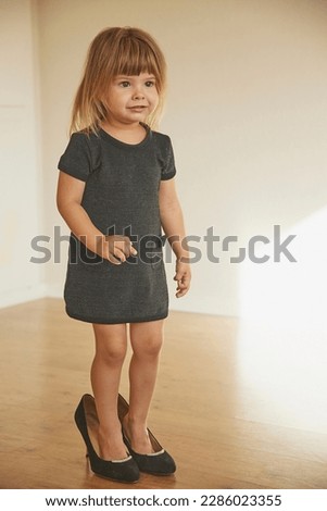 Charming child in a black evening dress at sunset.