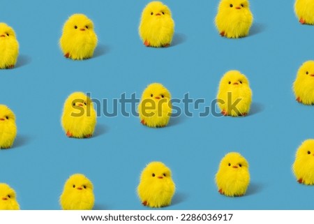 Funny yellow toy chicks on blue background, isometric pattern