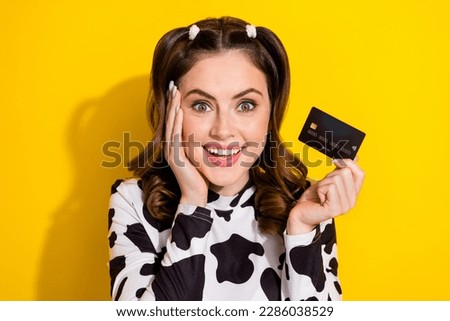 Photo of dreamy adorable girl wear cow skin shirt arm cheek rising bank card isolated yellow color background