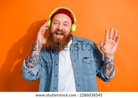 Photo of positive nice person arm touch headphones enjoy new song isolated on orange color background