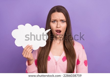 Portrait photo of dissatisfied unhappy girl brown hair stressed hold paper phrase chatterbox bad news confused isolated on violet color background Royalty-Free Stock Photo #2286038759