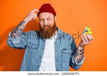 Photo of doubtful puzzled guy dressed denim jacket can not solve cube game isolated orange color background Royalty-Free Stock Photo #2286038791