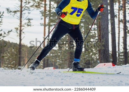 male athlete skier running cross country skiing, winter sports competition