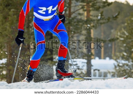 male athlete skier running skiing climb mountain, snow splashes from under skis and poles, winter sports competition