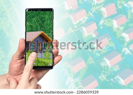 Cottage in phone screen. Hands with smartphone. Real estate agency application concept. Website for buying real estate. House selection via mobile phone. Digital real estate auction metaphor