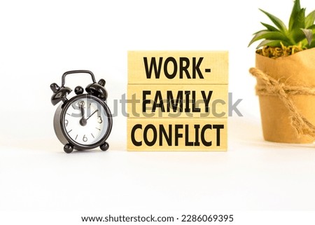Work-family conflict symbol. Concept words Work-family conflict on wooden block on a beautiful white table white background. Black alarm clock. Business work-family conflict concept. Copy space.