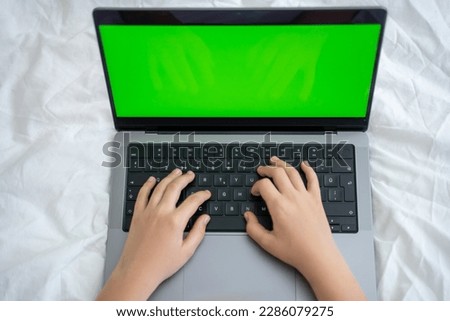 Close up smart caucasian middle School child using laptop green screen Chroma Key. Child typing on the keyboard. Online tutor teaching digital class, web lesson on computer at home. Virtual education