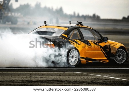 MotiBlurred car drifting on asphalt racing track with lot of smoke, motion blur drift caron Blur side view drift car Royalty-Free Stock Photo #2286080589