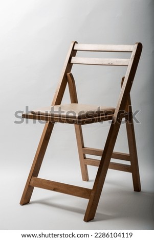 Folding chair made of wood. Folding chair with leather seat. Outdoor folding chair. Royalty-Free Stock Photo #2286104119