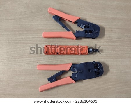 Two crimp tool and a terminal block punch tool in the middle. Telephone network line crimp tool and punch tool close-up