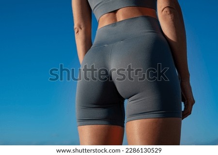 beautiful athletic female butt against the blue sky