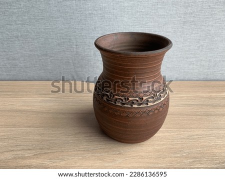 Clay pot handmade for liquid. Ceramic vase with ornament. Dishes made of clay and ceramics for wine.