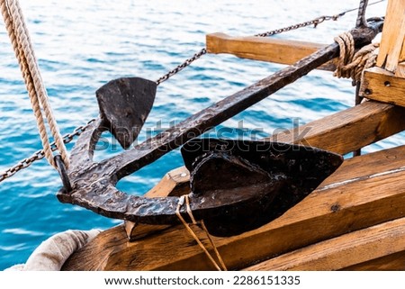 Anchor on deck. Rusty anchor tied with rope. Royalty-Free Stock Photo #2286151335