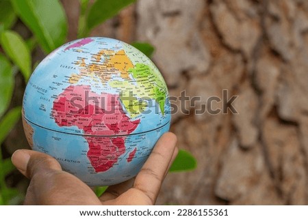hand holding a terrestrial globe with wooden texture background  showing Africa continent