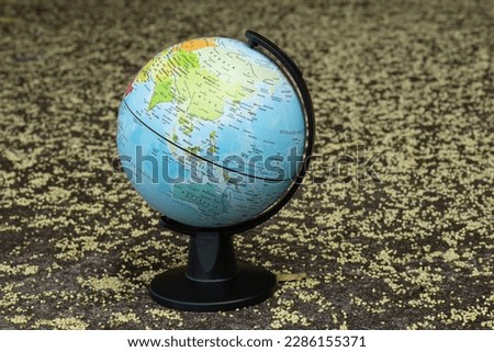 earth globe on a beige textured background showing continent Asia and Oceania