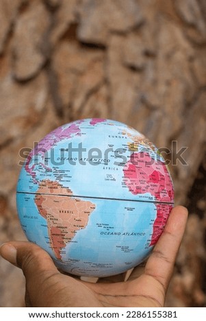 hand holding a terrestrial globe with texture background showing South America, Africa a little part of Europe