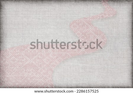 Greeting card for independence day of Latvia - latvian folk traditional clothing element - Lielvarde belt twisted like a way or road isolated on a grey linen cloth background