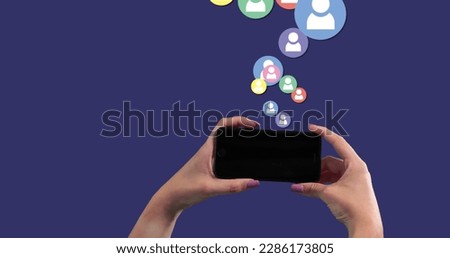 Image of a person using smartphone over social icons floating on blue background. Global economy and technology concept digital composite