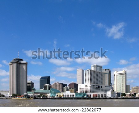 New Orleans Louisiana downtown skyline cityscape of the hotel district and commercial waterfront across the Mississippi River from Algiers on a sunny day with blue sky