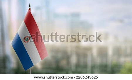 Small flags of the Paraguay on an abstract blurry background. Royalty-Free Stock Photo #2286243625