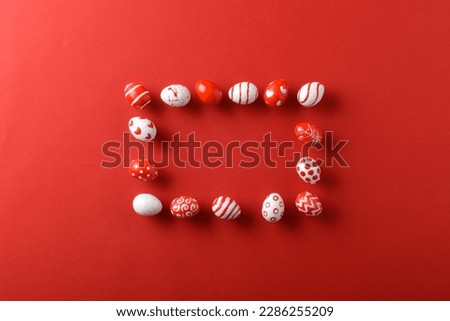 Easter backgrounds with a rectangular frame of Easter red and white eggs on a bright red background. Copy space. Flat lay, top view.