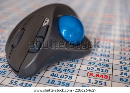 A wireless trackball mouse on a spreadsheet Royalty-Free Stock Photo #2286264629