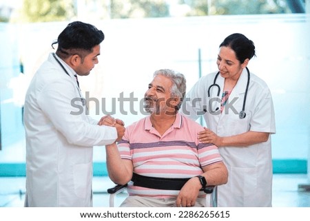 Doctors giving support to sick old man in a wheel chair Royalty-Free Stock Photo #2286265615