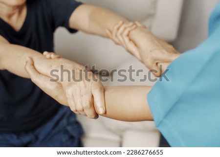 Close up hands of asian senior elderly woman with parkinson's disease symptom, hand numbness, finger lock, hand pain. Mental health and elderly care concept