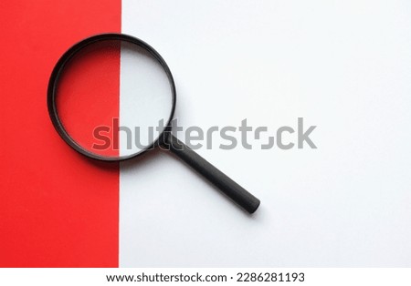 black frame a magnifying glass on Rectangle shape colored paper white and red background