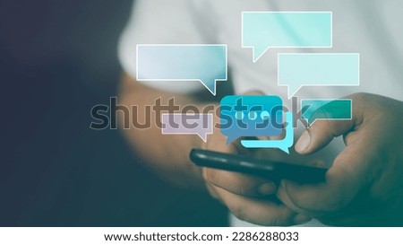 Text messages in cellphone screen with abstract hologram speech bubbles. Instant messaging app. Texting, group chat, sexting or sms concept. Customer service help desk with live support chatbot. Royalty-Free Stock Photo #2286288033