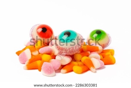 Halloween candy jelly eye, pumpkin marshmallows, corn candy isolated on white background.Classic candy sweets for Halloween with.Halloween holiday concept with candy corn and jack o lantern.