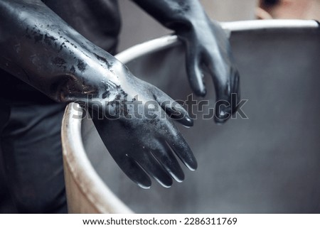 Latex industrial chemical rubber gloves protecting hands from toxic acidic chemical compounds in an industrial chemical factory. Acid bath and virus protection marigold latex gloves. Royalty-Free Stock Photo #2286311769