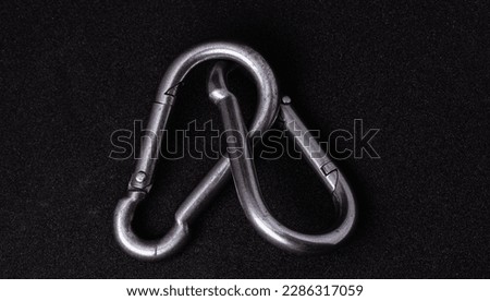 Two metal carabiners for ropes isolated on a black background.