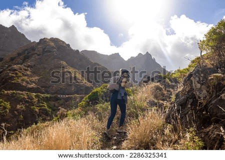 Woman with backpack walking on a panoramic hiking trail in the mountains of Anaga massif between Afur and Taganana on Tenerife, Canary Islands, Spain, Europe. Hill landscape in UNESCO Anaga rural park Royalty-Free Stock Photo #2286325341
