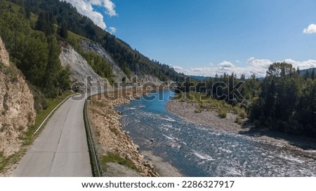 The Turquoise Katun river from a height on the road to the village of Multa. Road landscape with mountains and a river. Photographs of the Republic of Gorny Altai in summer, Ust-Koksinsky district,