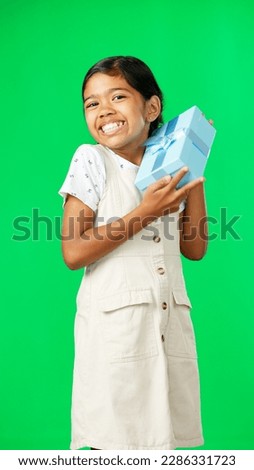 Excited, gift and face of a girl on a green screen isolated on a studio background. Shaking, happy and portrait of a girl with excitement about a birthday, Christmas or holiday present on a backdrop
