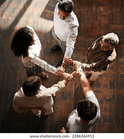 Teamwork, strong and people with linked hands in support, collaboration or team building power in business startup. Group circle, women or connected men in hand synergy sign for solidarity from above