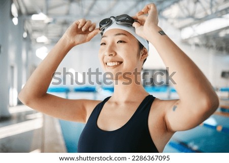 Professional swimming, asian woman with smile and goggles at pool for training, wellness and winner mindset. Water sports, workout and champion athlete swimmer at competition with smile and happiness Royalty-Free Stock Photo #2286367095