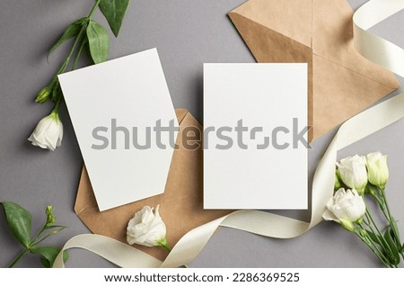 Blank wedding invitation card mockup with envelope and white eustoma flowers, mockup with copy space
